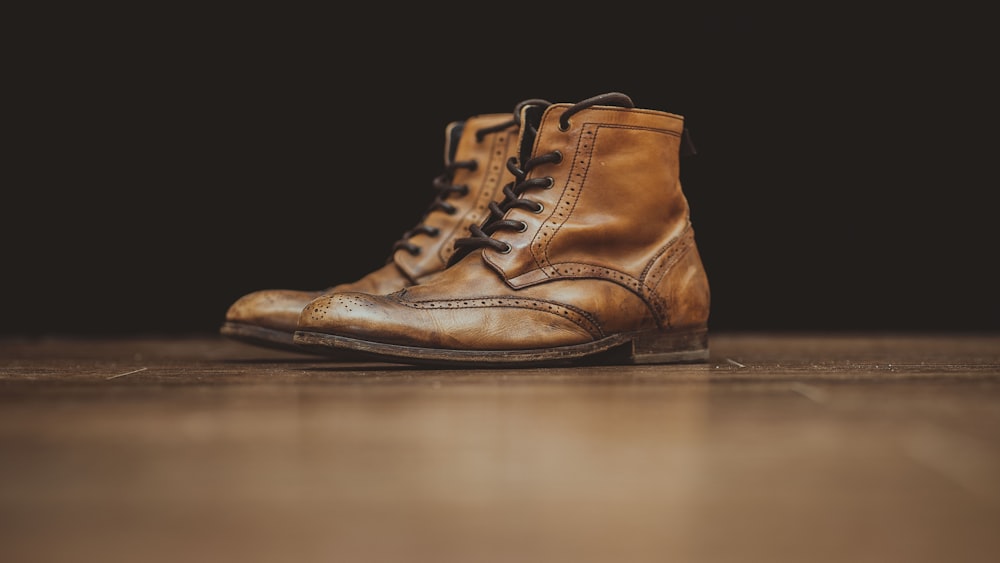 pair of brown leather booties on brown surface