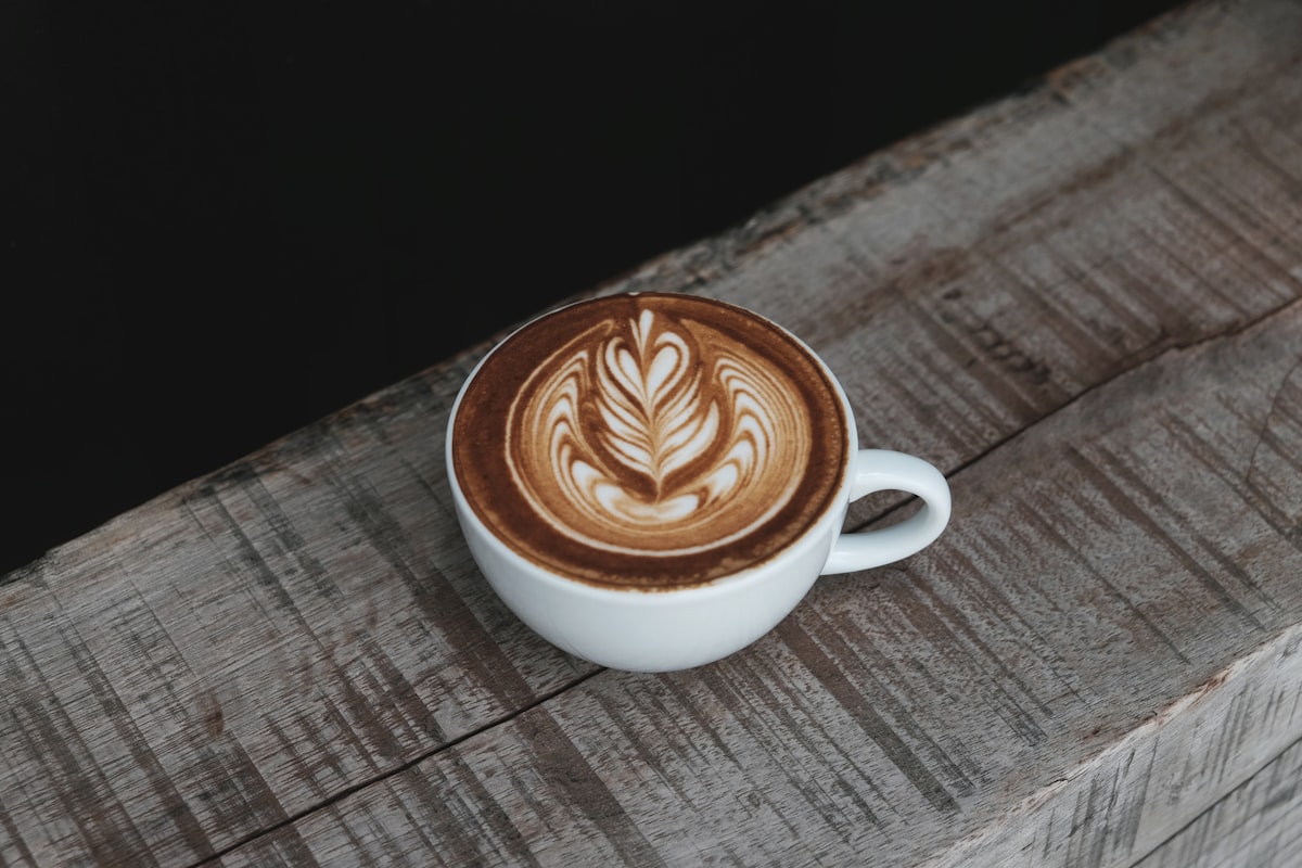 A cappuccino in a white ceramic cup at a Thai coffee shop