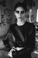 Model wearing bold, trendy makeup walking through a bustling city street.