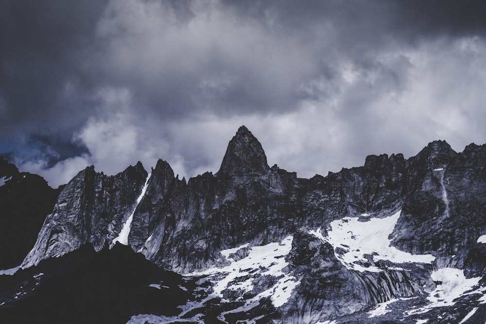 snow covered mountain under white clouds