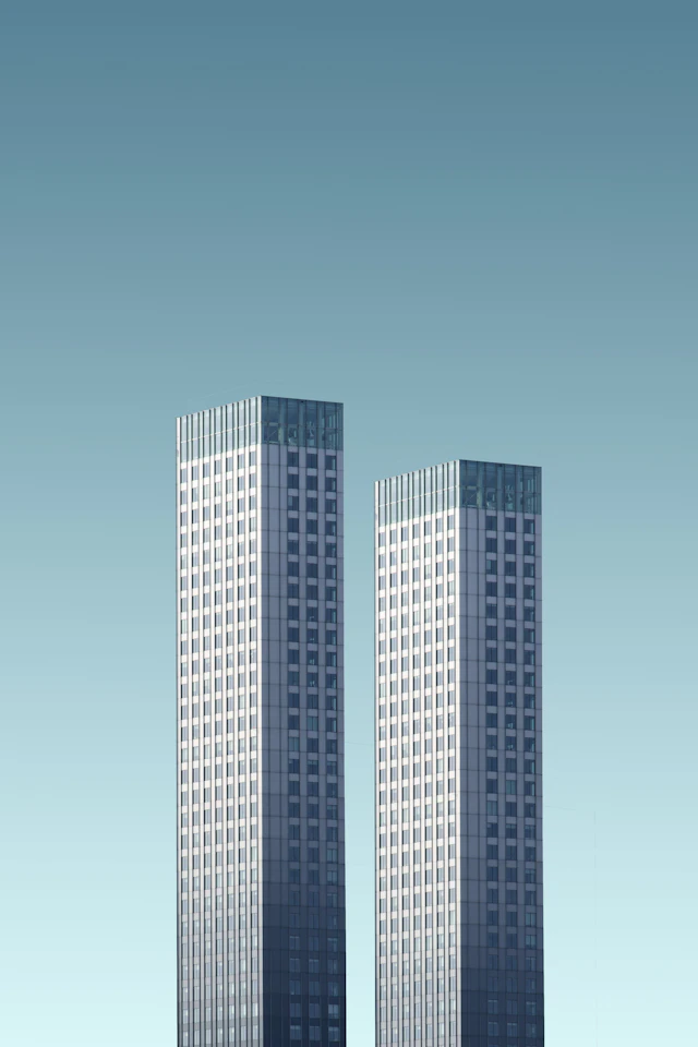 Two teal and white towers rising side by side