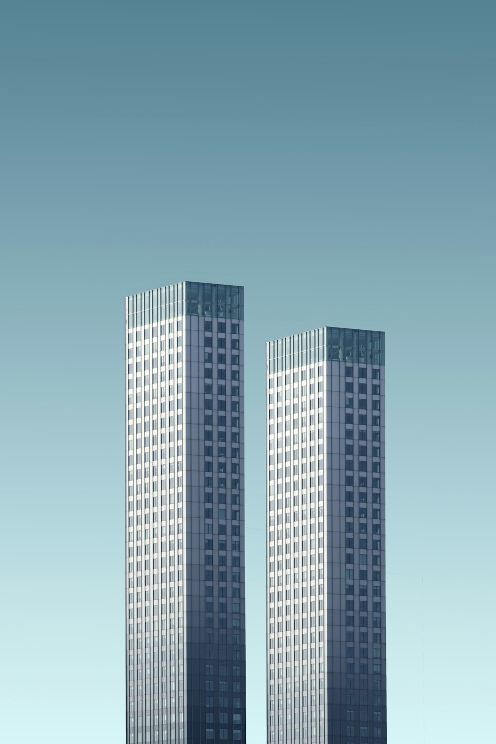 two teal-and-white skyscrapers