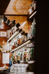A cozy bar with eclectic decor and a variety of drinks on display.