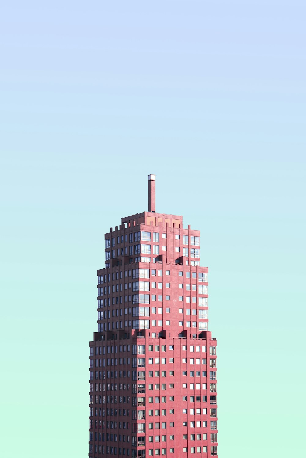 Edificio rojo de gran altura bajo cielo azul