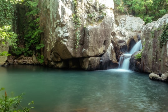 brown rock formation near waterfalls in Río de la Miel Spain