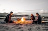 three men in front of bonfire