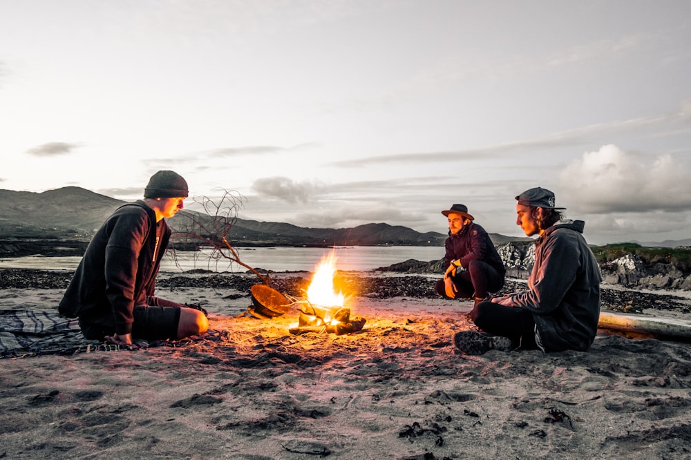 three men in front of bonfire