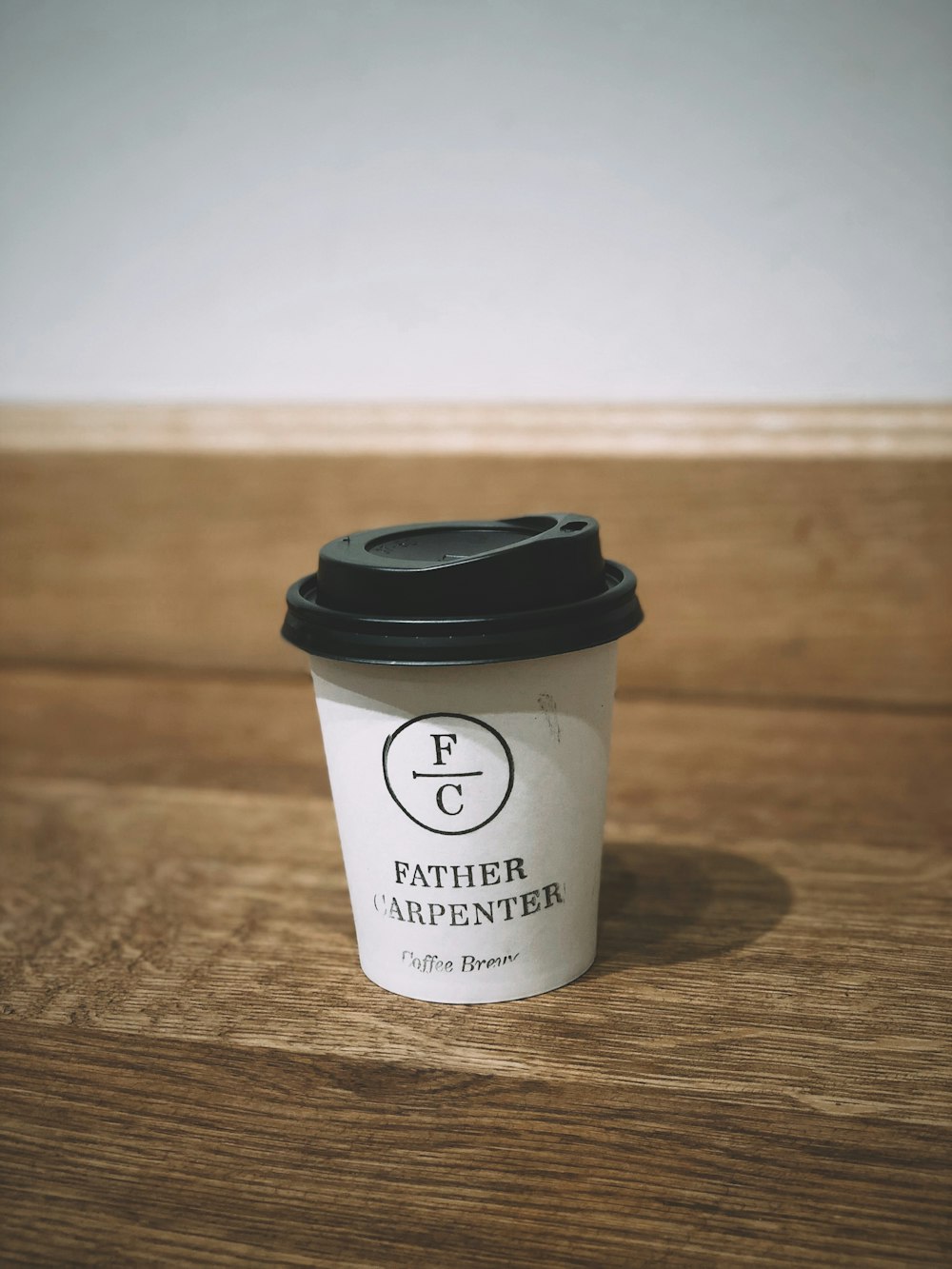 shallow focus photo of coffee cup on brown wooden surface