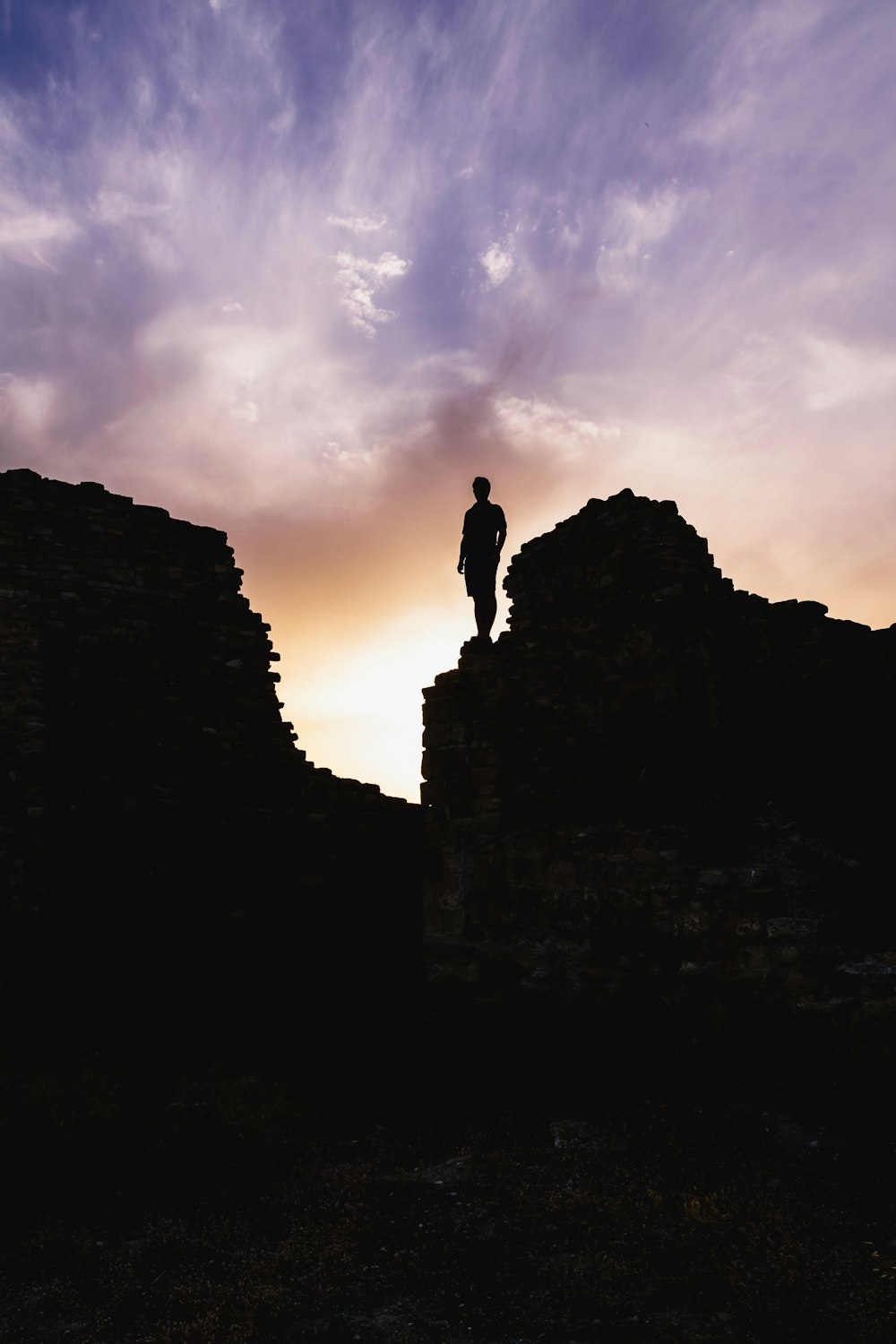 silhouette dell'uomo in piedi sulla formazione rocciosa