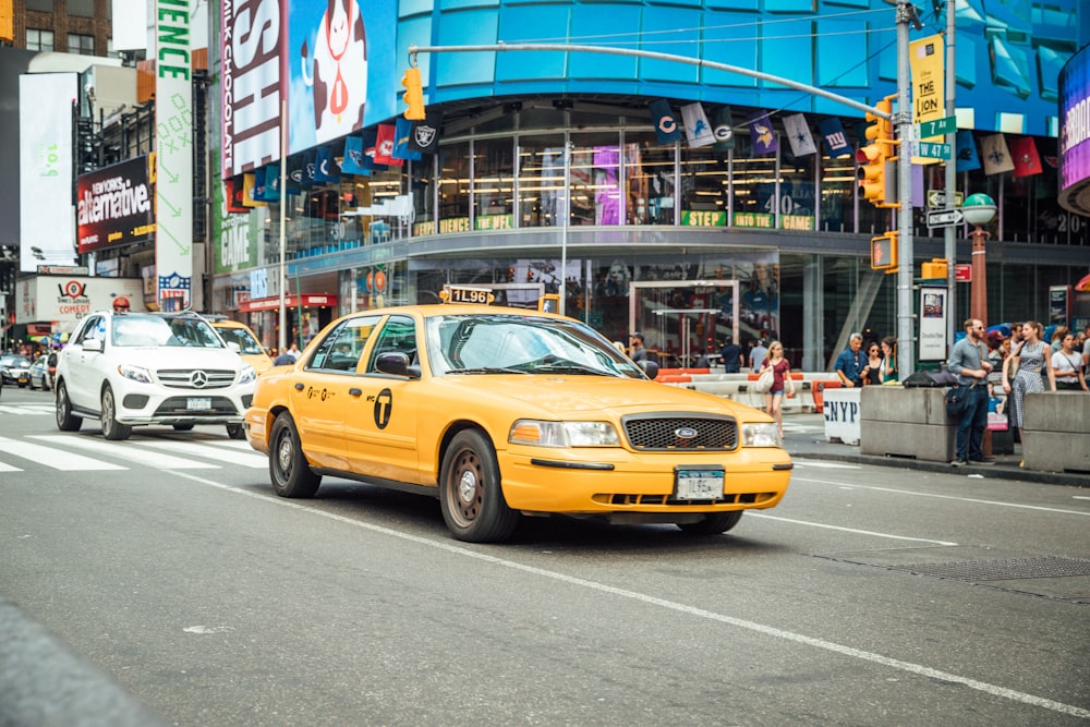 yellow taxi cab near white car
