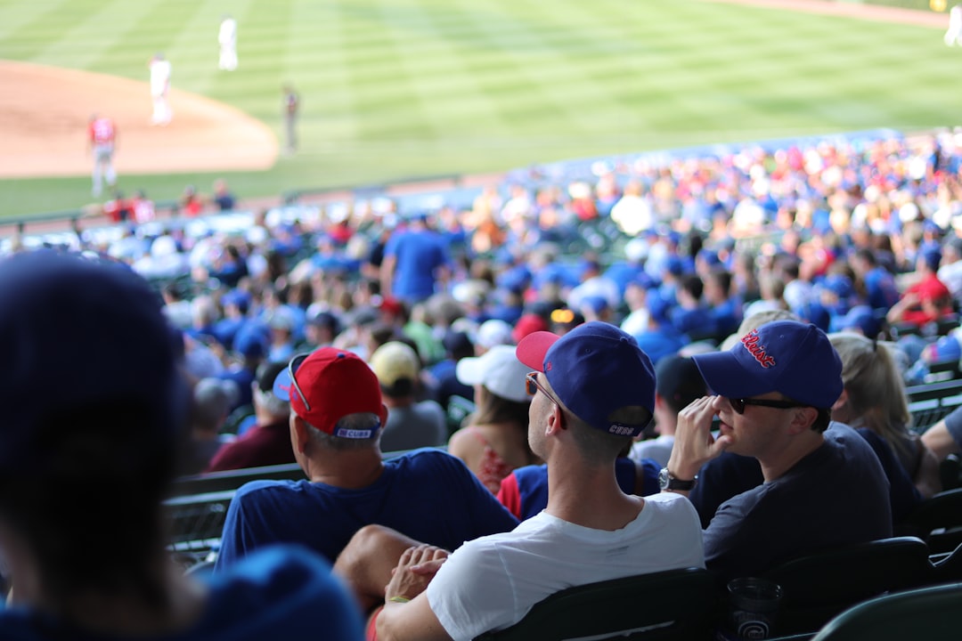 people sitting on stadium watching sports,