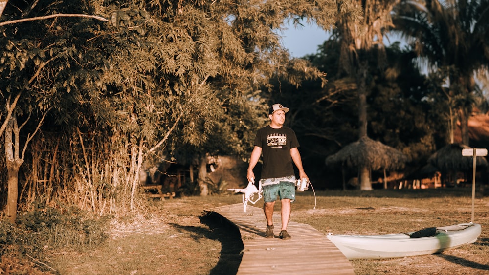 man walking on dock holding rod during daytime