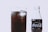 A close-up view of a glass filled with a dark, fizzy liquid and ice cubes. Next to the glass, there is a Coca-Cola bottle with the original taste label visible on it.