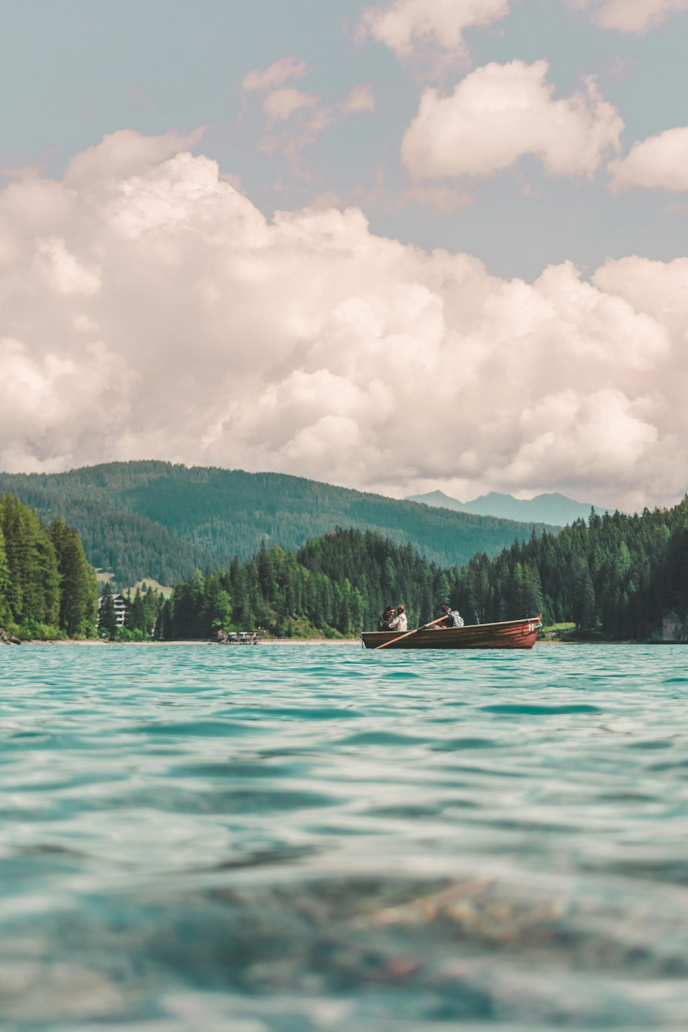 three person riding boat on body of water during daytime