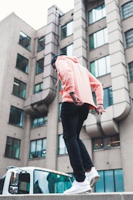 man walking near vehicle and building