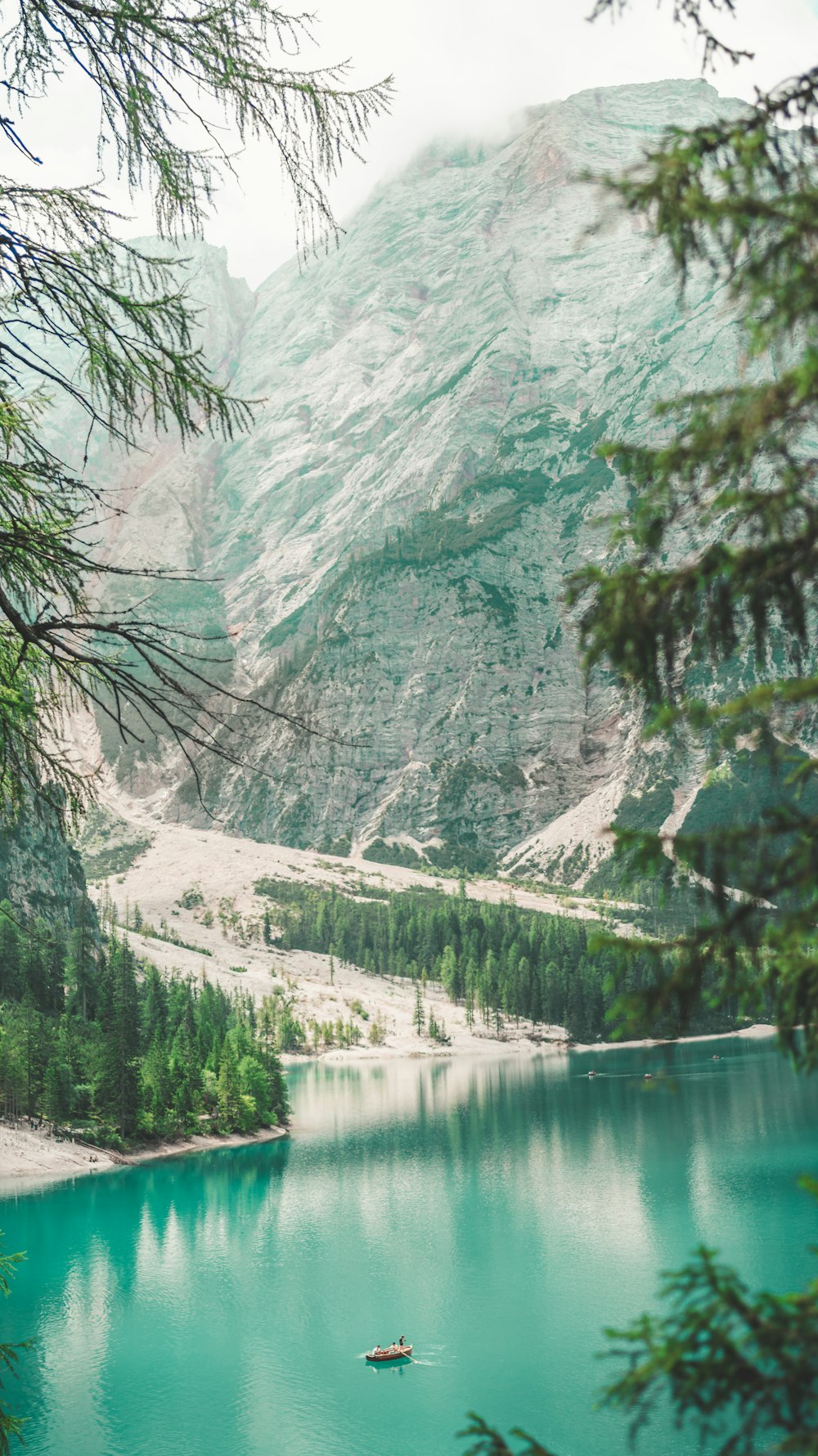 a boat floating on top of a lake surrounded by mountains