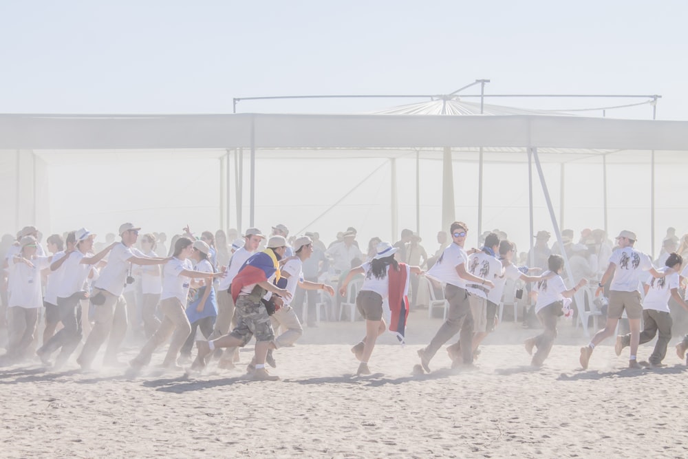 group of people running on sand ground