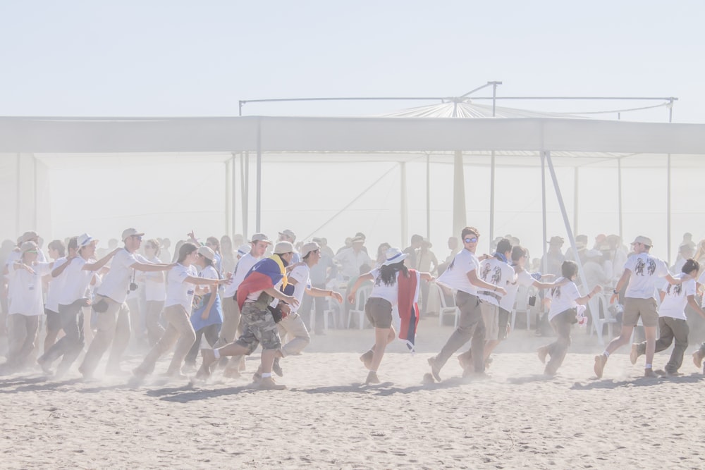 grupo de personas corriendo sobre suelo de arena