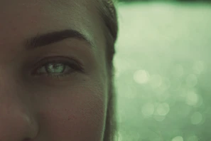 Detailed shot of freshly applied lashes with a soft green matcha background highlighting freshness