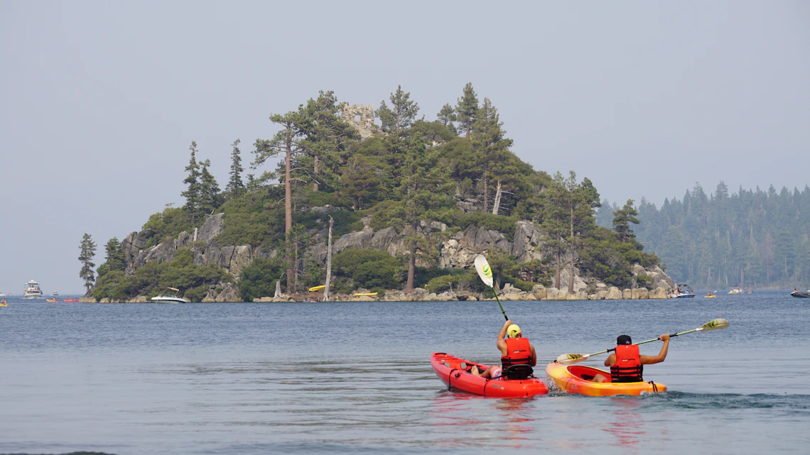 Kayakers exploring a pristine blue lake surrounded by natural scenery