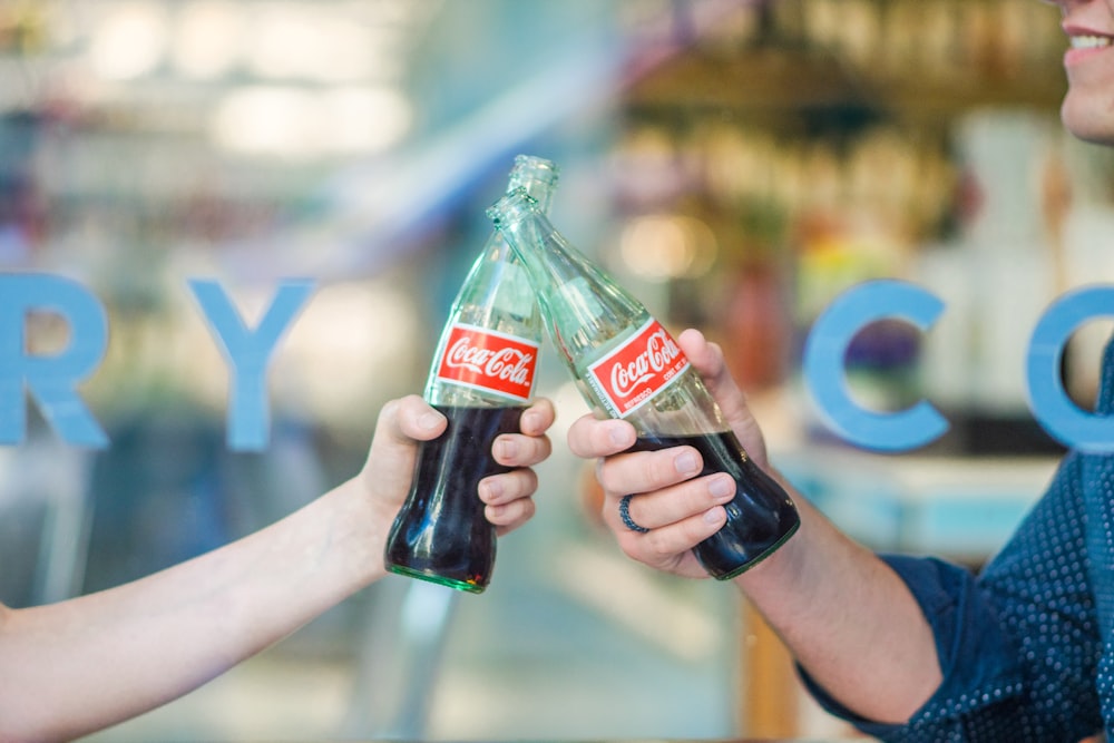 person holding Coca-Cola bottle