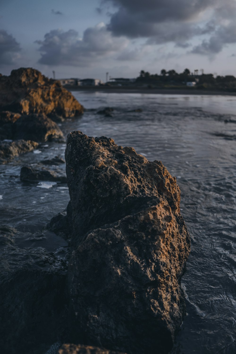 selective-focus photography of rock formation by body of water during daytime