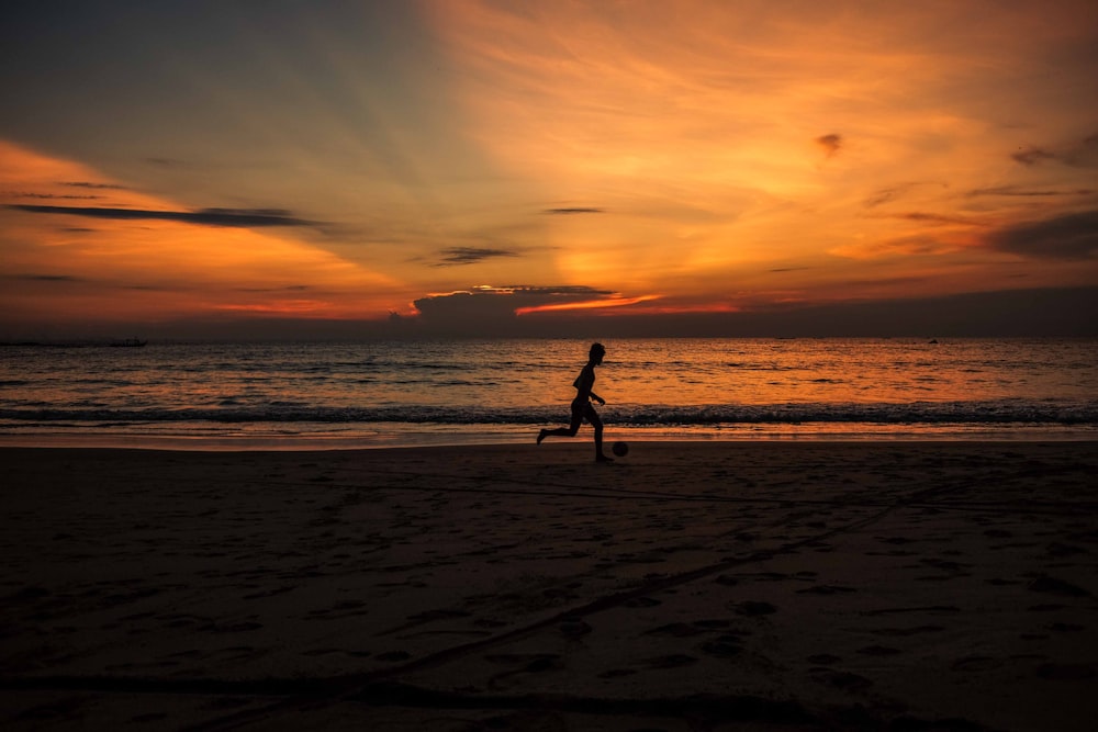 silhouette photo of person running near the shore