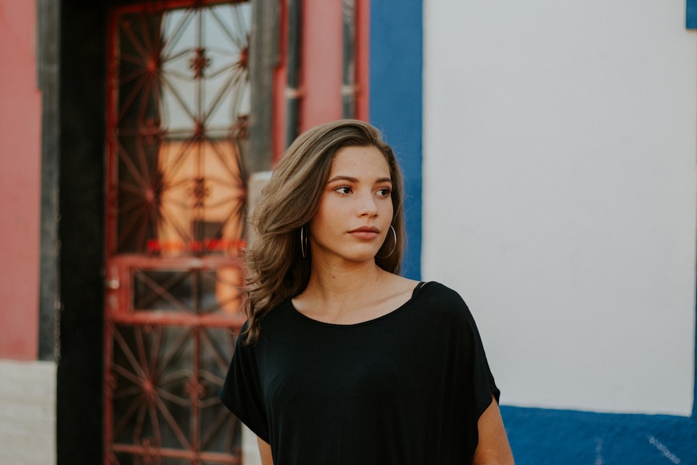 woman looking side near white and blue wall