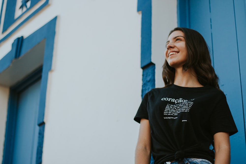 woman standing near white and blue building