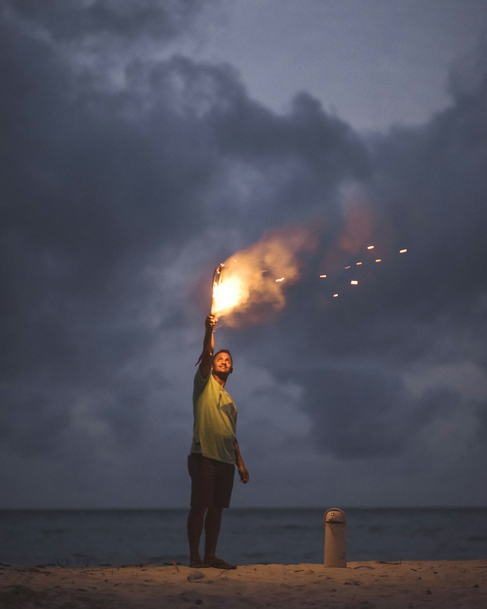 homme tenant une torche sur le sable blanc