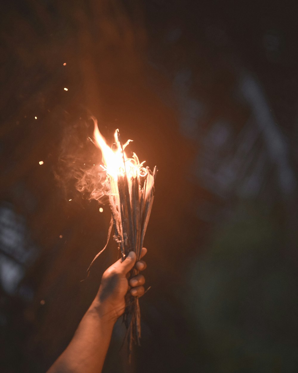 person holding burning sticks