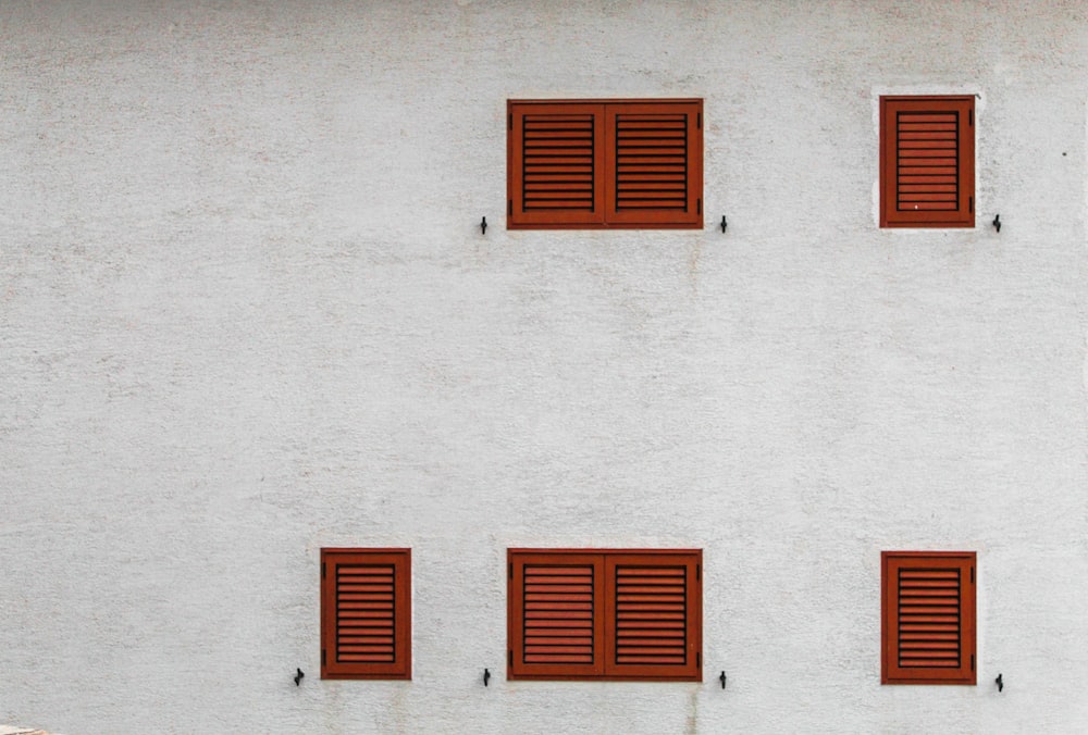 Edificio gris con ventanas de persianas marrones