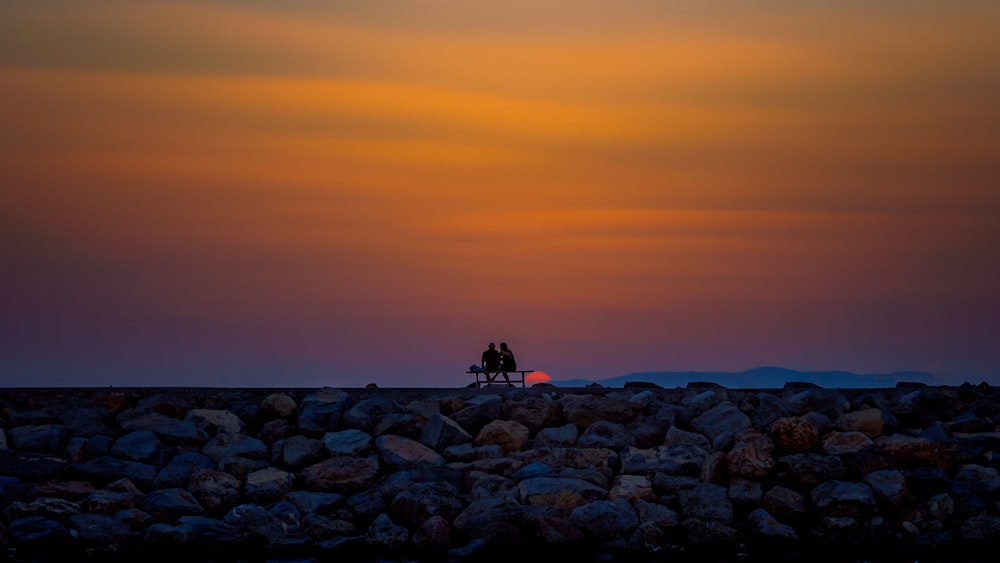 silhouette photography of person sitting on bench