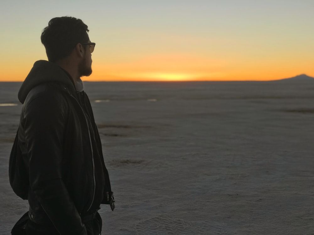 hombre de pie en el desierto mirando a lo lejos