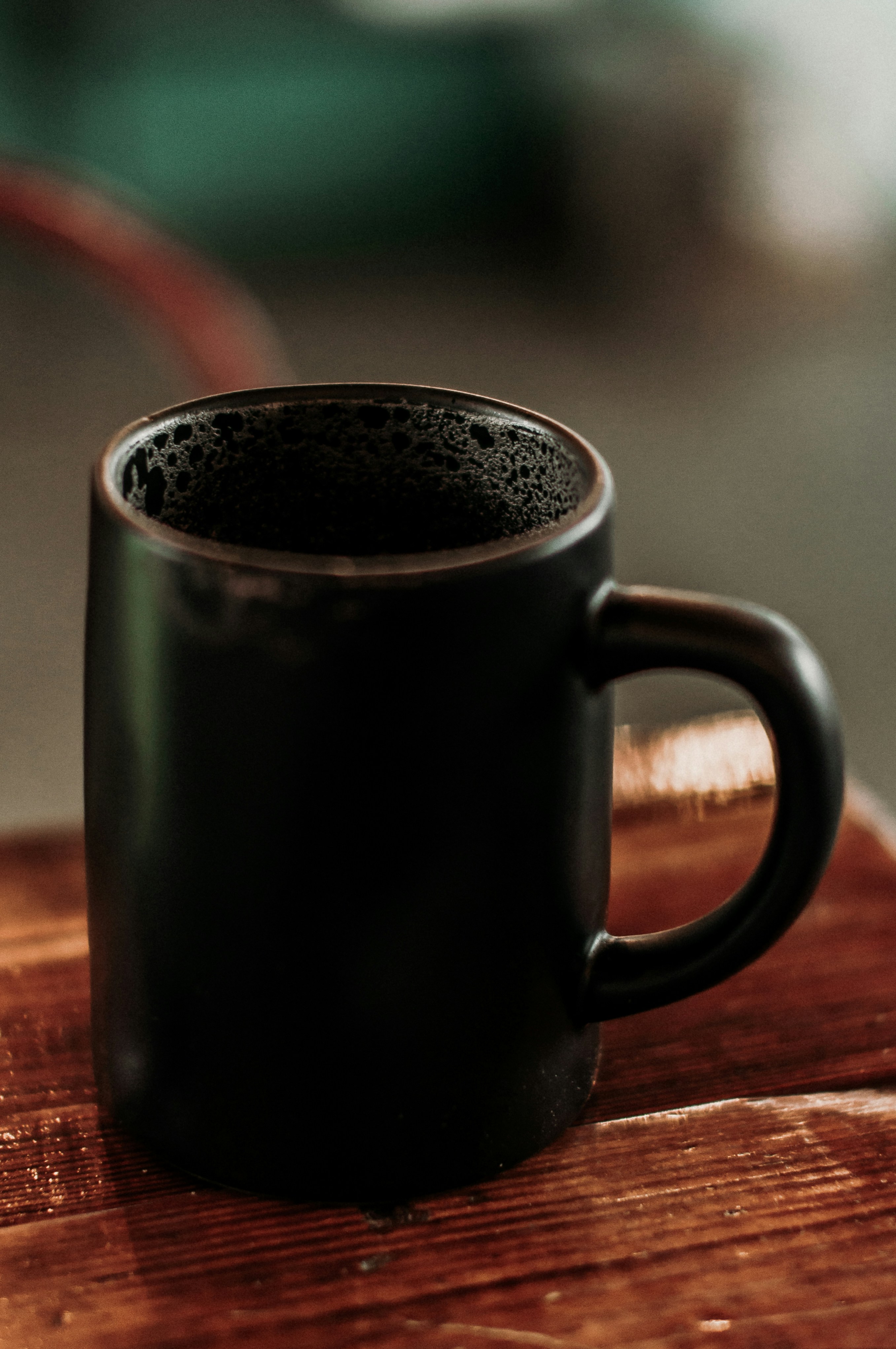 black ceramic mug on brown surface