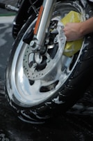 Detail shot of a technician carefully polishing a motorcycle wheel.