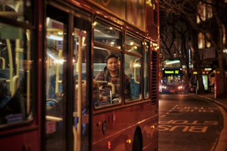 A sleek 16-seater mini bus parked on a London street with happy passengers boarding.