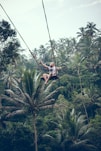 man swinging over forest