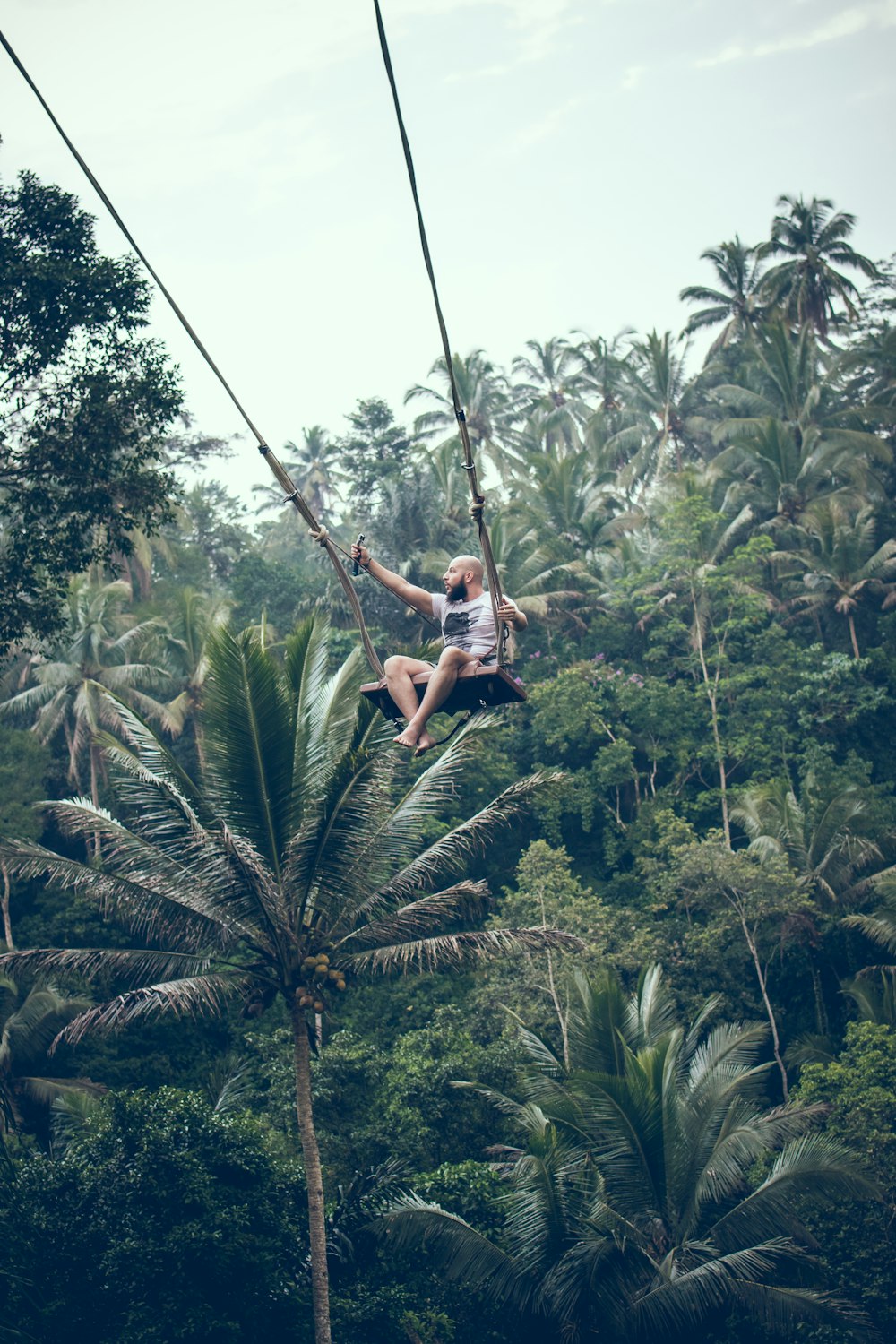 man swinging over forest