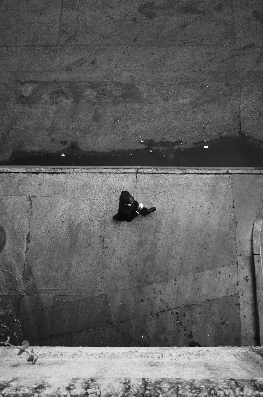 Photo en niveaux de gris d’un homme marchant sur le trottoir