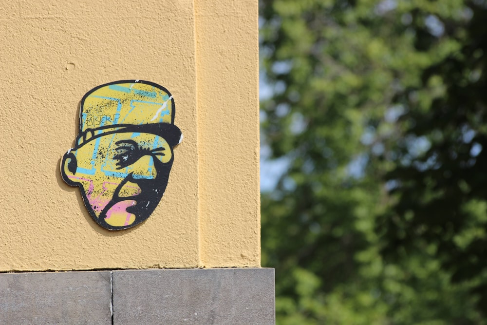 a sticker of a man's face on a yellow wall