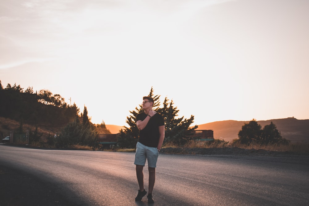 man standing on road