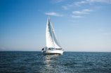 blue and white sailboat on ocean during daytime