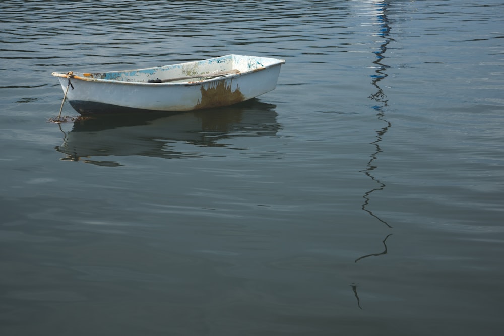 una piccola barca che galleggia sopra uno specchio d'acqua