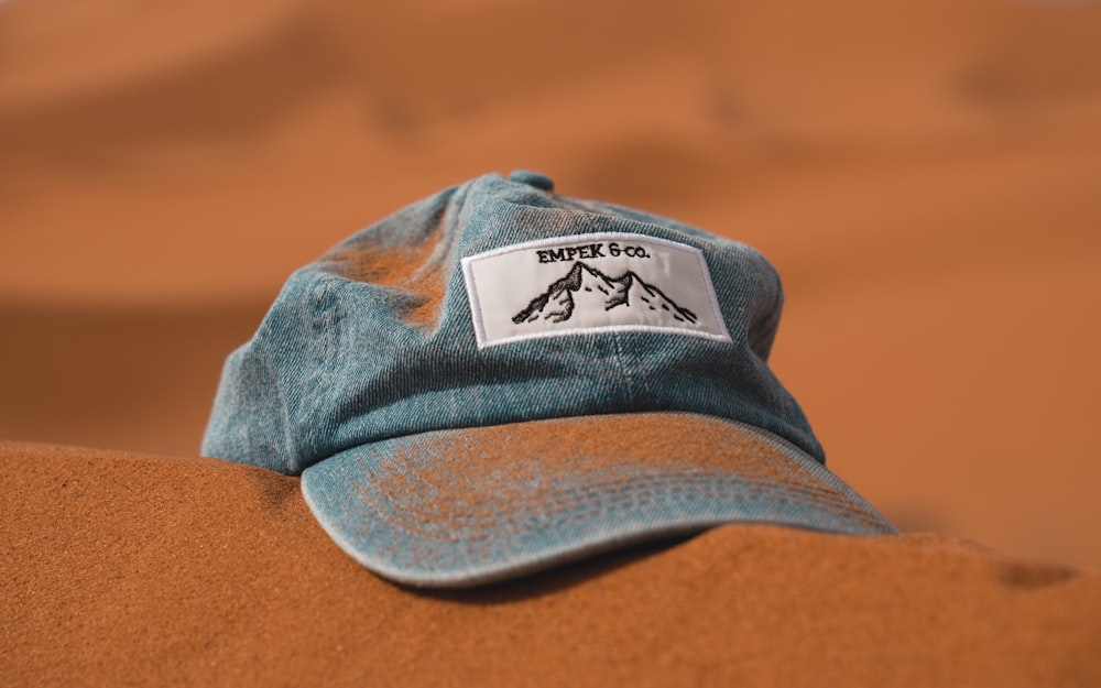 Gorra azul sobre arena marrón