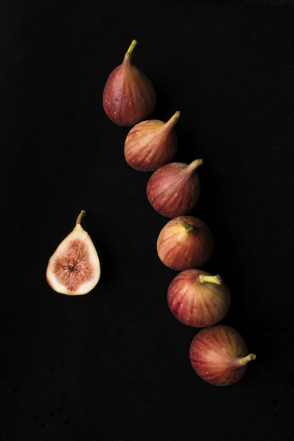 six onions on black surface