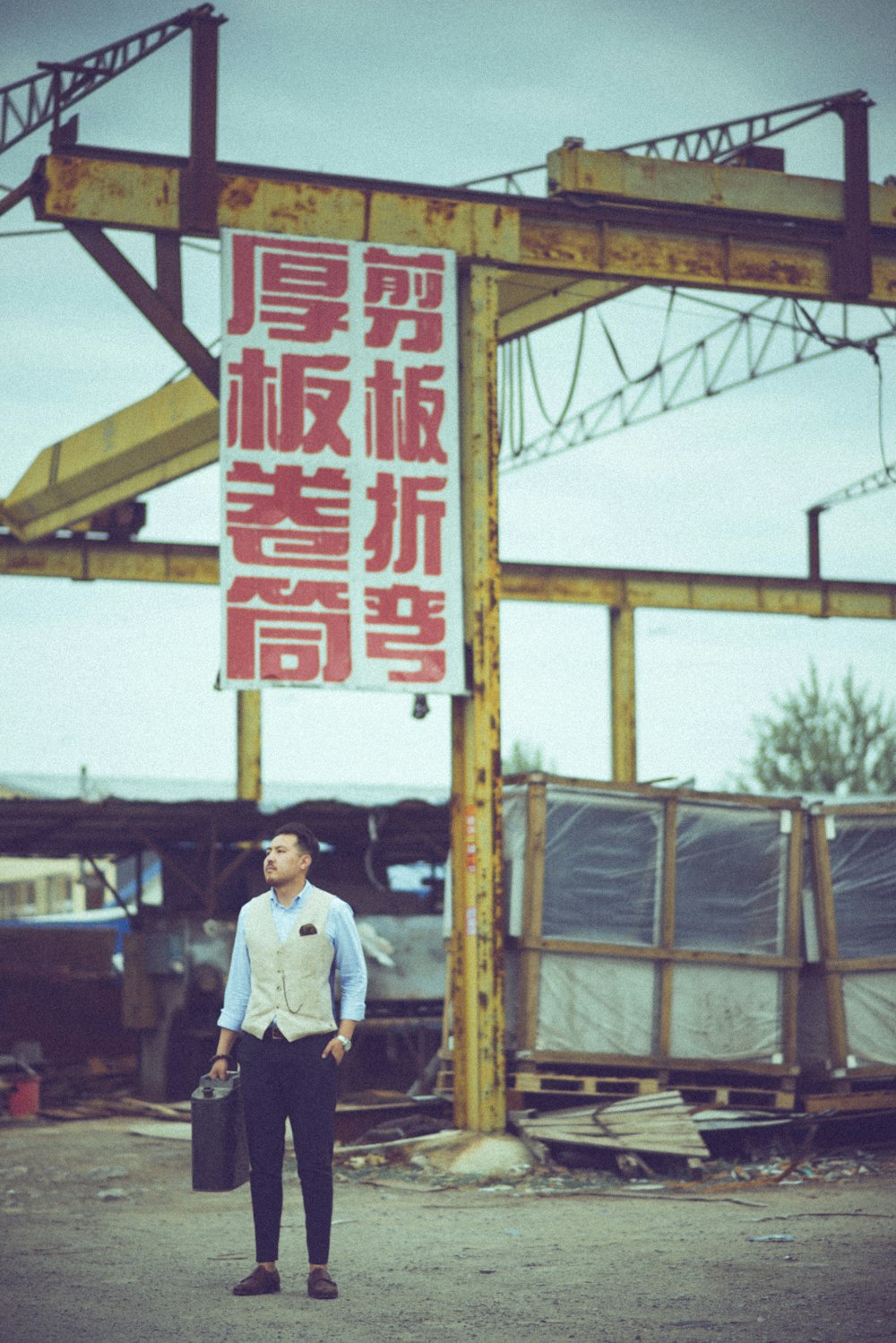 man carrying case standing near signage board