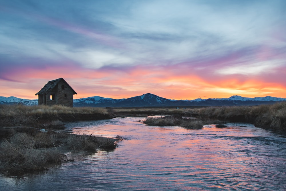 casa accanto al fiume sotto il cielo nuvoloso