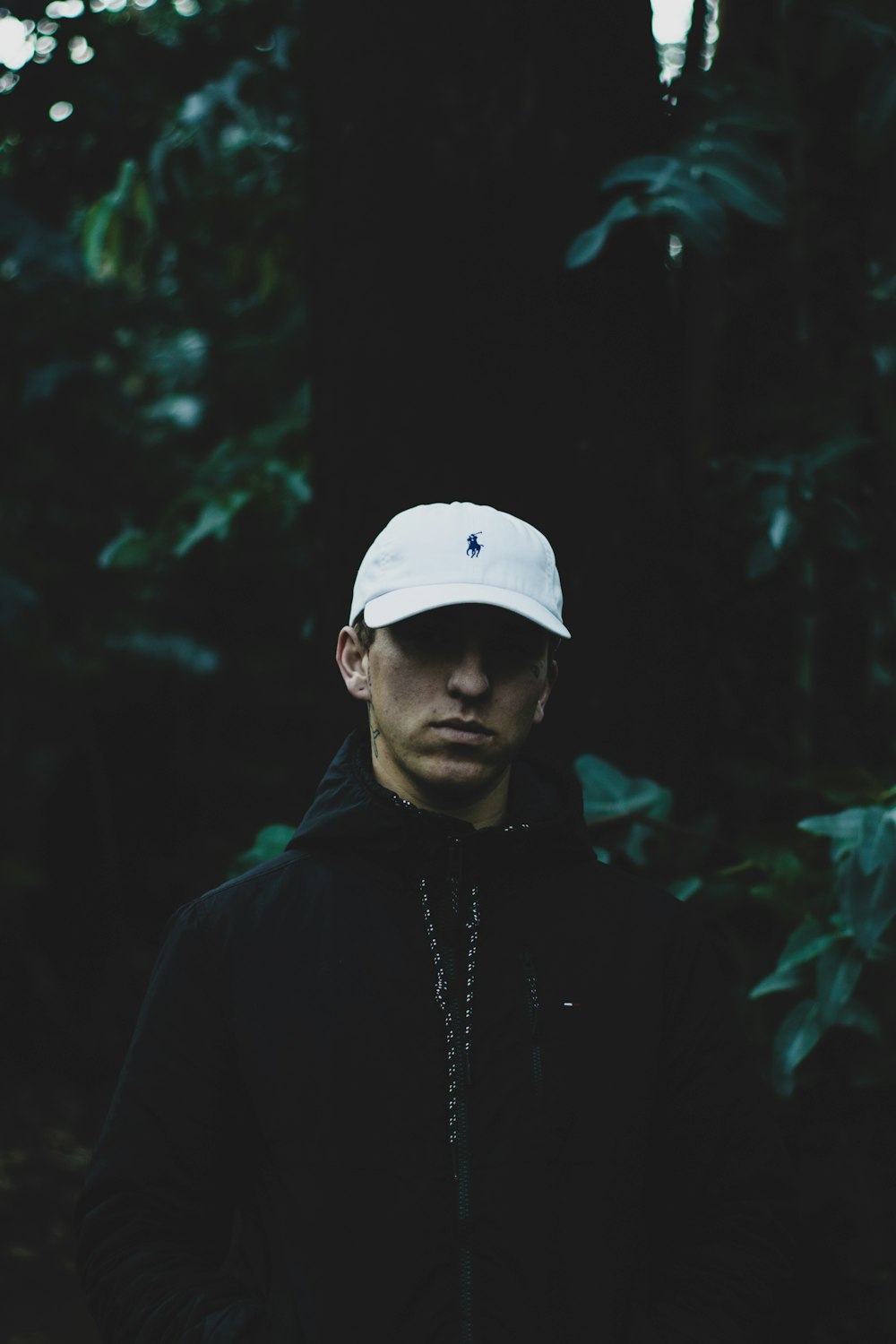 closeup photo of man in front of green leafed tree