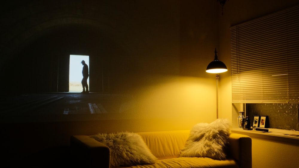 photo of beige padded sofa near floor lamp with window blind